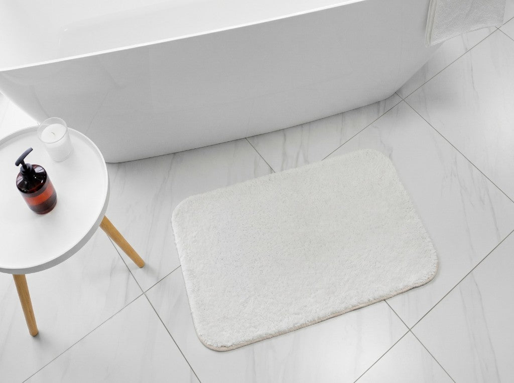 White bathroom mat next to bathtub, sublimation-ready plush surface